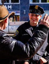 SFPD officer smiling at man wearing cowboy hat