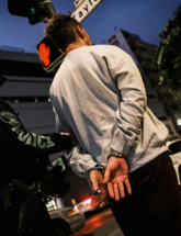 Suspect being led in handcuffs by officer