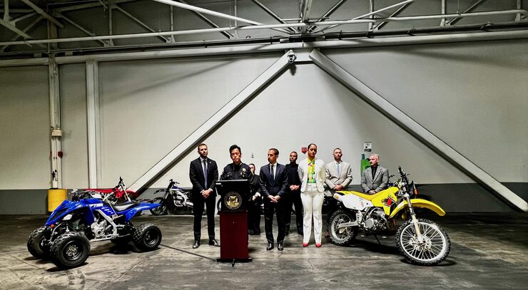 Image of Interim Chief Paul Yep and city officials standing amongst dirt bikes seized during operation