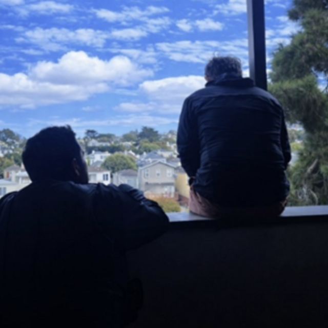 Image of officer talking to person sitting on ledge