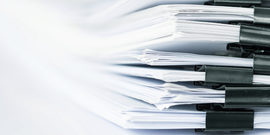 Image of papers organized and stacked together with binder clips
